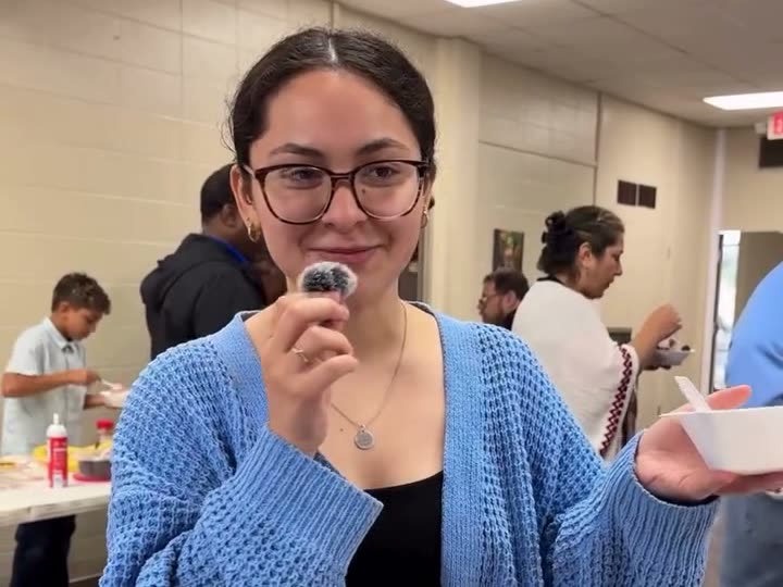 A smiling woman in a blue cardigan at a church gathering